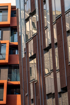 Modern urban brick facade architecture with orange accents and repeating windows showing geometry pattern texture for abstract background design
