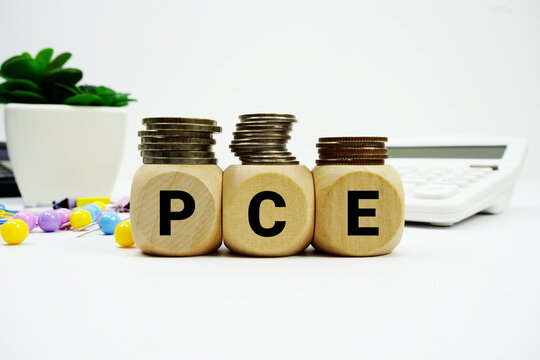 Stack of coins with wood blocks with "PCE (Personal Consumption Expenditures)" Financial concept