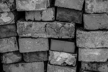 Close-up of stacked old bricks with cracks, rough surfaces, and irregular alignment, forming a...