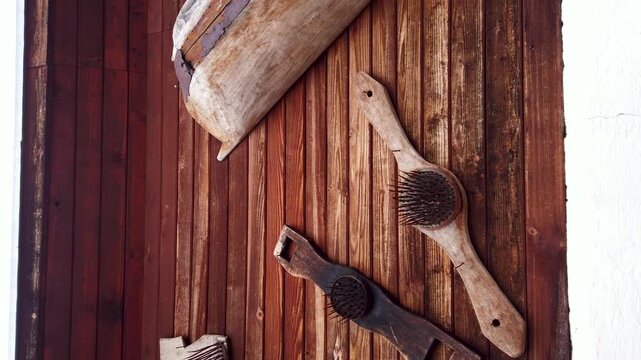  Antique flax hackles and vintage wooden tools on wooden wall 