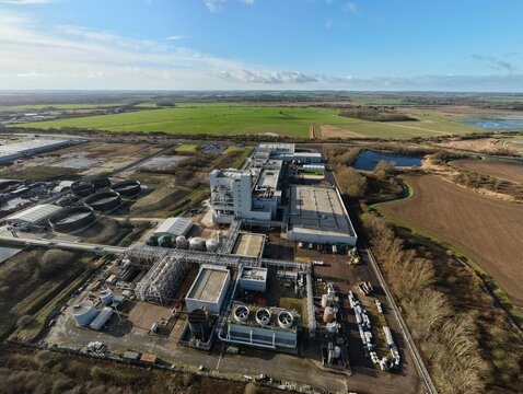 Aerial view of the Lenzing Fibers plant, a complex of industrial buildings contrasting against the vast green fields beyond, Grimsby, England, United Kingdom.