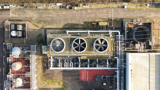 Aerial view of industrial complex with cooling towers and pipe networks creating an intricate pattern of shadows and textures, Grimsby, England, United Kingdom.