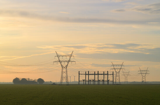Power lines and transformer station on Flevopolder in the Netherlands at sunset