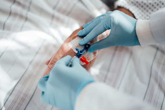 Doctor administering intravenous treatment to patient in clinic