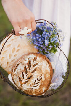 Fresh sourdough bread with forget me not flowers in a basket outdoors