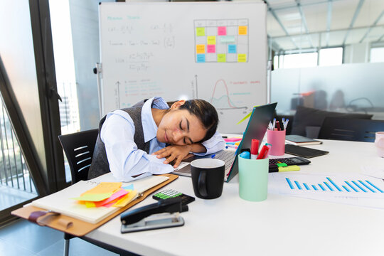 Manager sleeping at desk in office after work fatigue and stress