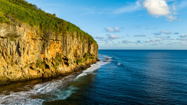 Limestone cliffs and coastline at sunset in Rurutu, French Polynesia