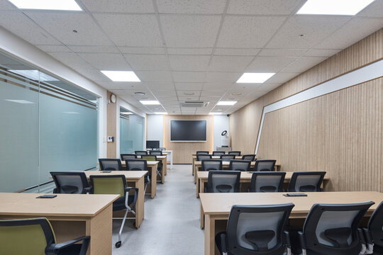 Modern classroom or computer lab with desks and chairs, empty interior.