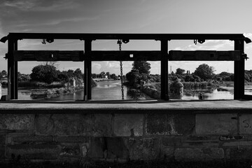 View through the metal mechanism of the historic Stone Lock (Kamienna Sluza) overlooking the Motlawa River and fortifications, Gdansk, Pomerania, Poland, Europe. © sebastiangora