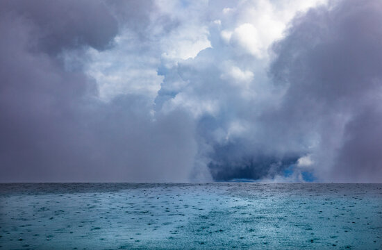 Dramatic cloudscape over rippled swimming pool surface in rain