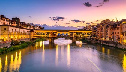 Fototapeta premium City river view with stone bridge connecting buildings under a vibrant sky during dusk, reflecting on the water