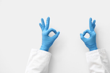 Obraz premium Female doctor's hands showing OK on white background