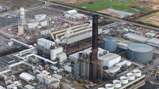 Aerial view of the industrial complex, dominated by towering structures, plumes of vapor, and sprawling infrastructure, Immingham, United Kingdom.