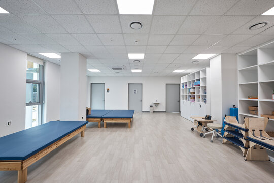 Clean modern hospital or clinic interior with patient beds and medical facility lighting.