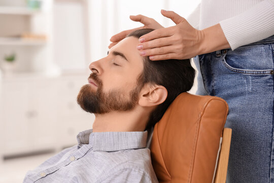 Female psychologist hypnotizing man in office, closeup