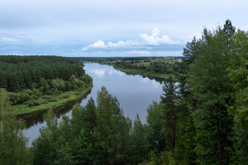 Obraz premium a river with clouds and a forest