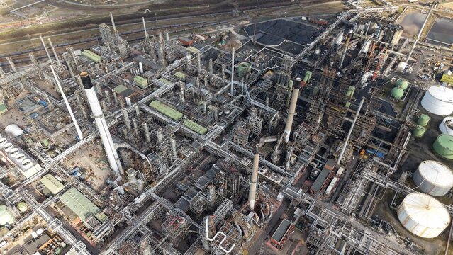 Aerial view of a sprawling industrial complex of Humber Refinery reveals a maze of pipes, tanks, and towers under a muted sky, Immingham, United Kingdom.