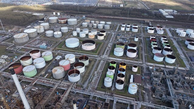 Aerial view of a sprawling industrial landscape with tanks reflecting the sky, a stark contrast to the surrounding greenery, Immingham, United Kingdom.