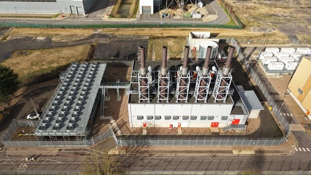 Aerial view of the industrial complex with stark contrasts between the metallic silver of the cooling units and the dark vertical lines of the exhaust stacks, Brigg, United Kingdom.