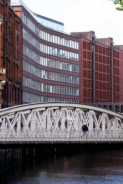Historic brick waterfront architecture meets an urban bridge over a canal in Hamburg HafenCity Germany capturing industrial character within the city
