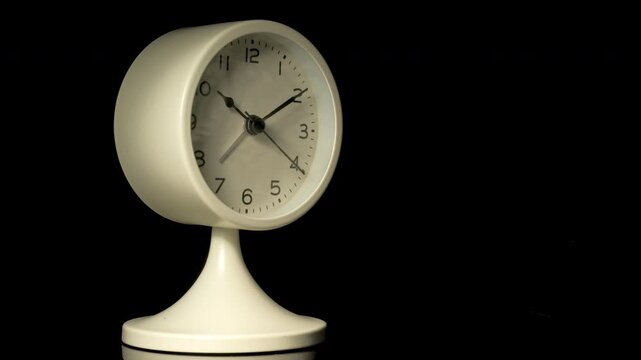 Tme lapse video of a clock time passing over a day to night on black background.