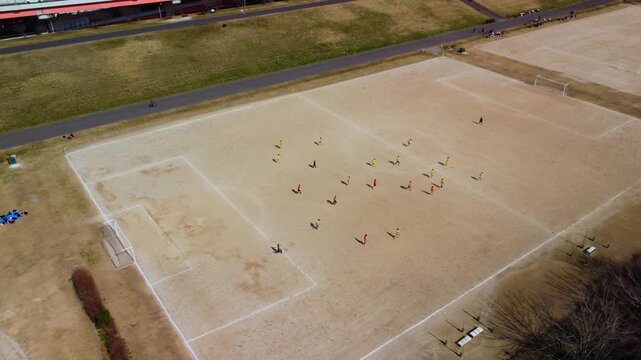 土手でサッカーをする少年たちを空撮　4K