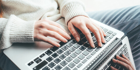 Fototapeta premium Young woman working on her laptop computer. Remote work concept.