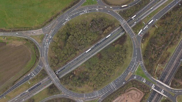 Aerial view of the intricate roundabout interchange with dense trees in the center, facilitating smooth traffic flow, Sutton Coldfield, England, United Kingdom.