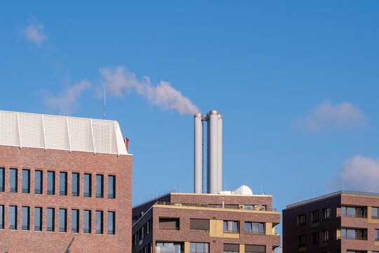 Brick architecture of industrial factory building with smokestack on Hamburg Germany skyline against bright sky in daylight