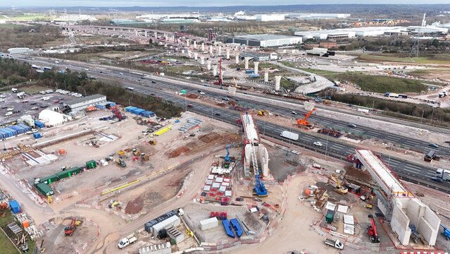 Aerial view of construction with towering structures piercing the skyline, a symphony of steel and concrete against the backdrop of the landscape, HS2 Water Orton Central, Birmingham, United Kingdom.