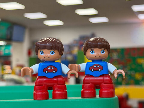 Two duplo toy figures with car shirts