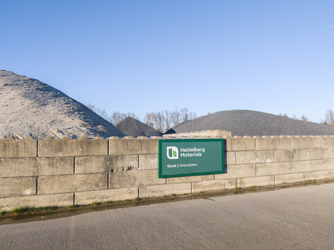 Sign of Heidelberg materials on wall, bulk storage system at industrial plant for building materials heap of sand, pebbels for production of concrete. Industrial installation, building industy. Heap.