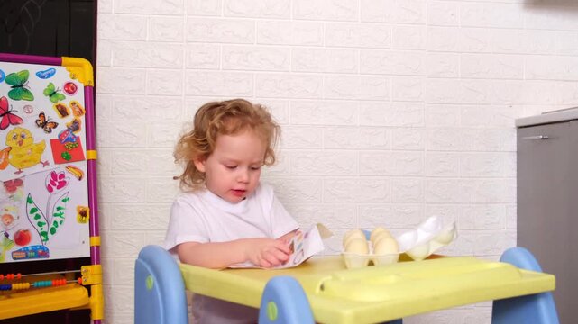 Moscow, Russia, 12.04.2025 A woman is holding a baby and they are sitting at a table. The baby is looking at something on the table