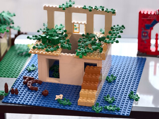 Fototapeta premium Overgrown lego two-story house with roof foliage