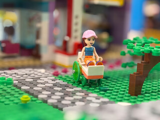 Naklejka premium Lego minifigure in wheelchair on park path