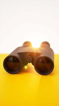 A pair of binoculars on a yellow and white background symbolizing vision and discovery.