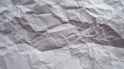 Obraz premium Crumpled white paper texture background with natural wrinkles and soft shadows, abstract messy paper surface pattern for creative design backdrop and realistic stationery material