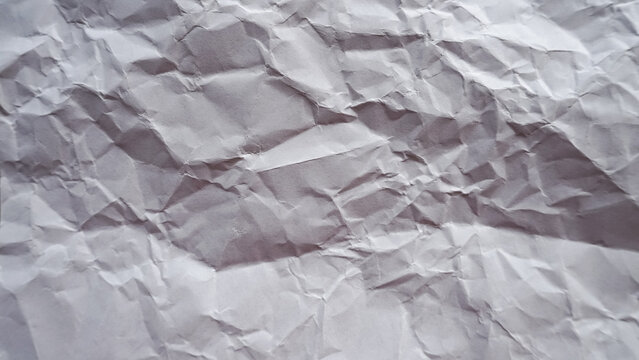 Crumpled white paper texture background with natural wrinkles and soft shadows, abstract messy paper surface pattern for creative design backdrop and realistic stationery material