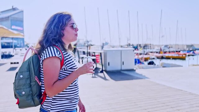 Young Woman Walking On Jaffa Port Promenade With Drink