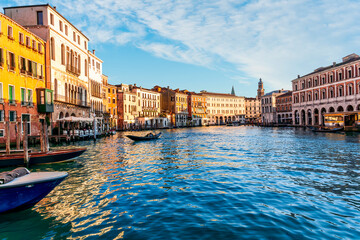 Obraz premium romantic view of a canal in Venice with boats and blue water and beautiful vintage buildings around the cityscape