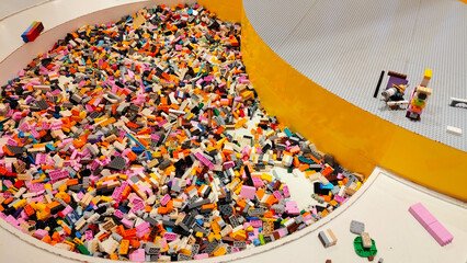 Naklejka premium High angle view of a large circular play area filled with numerous colorful plastic Lego bricks and building blocks in a modern indoor playground on January 3, 2026 in Bangkok, Thailand.