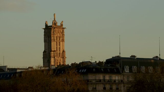 The Saint Jacques tower in Paris at sunrise  with a plane passing by in the background