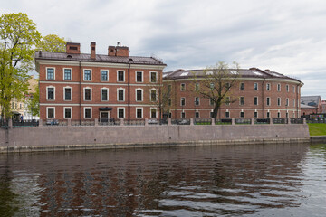 The building of the ancient prison "Bottle" in the urban landscape on a cloudy May day. New Holland Island, Saint Petersburg