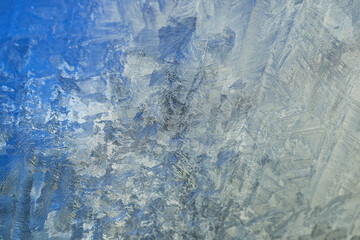 Intricate Blue and Silver Frost Patterns on a Winter Windowpane