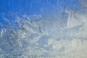 Naklejka premium Vibrant Blue Frost Patterns on Window Glass Winter Background