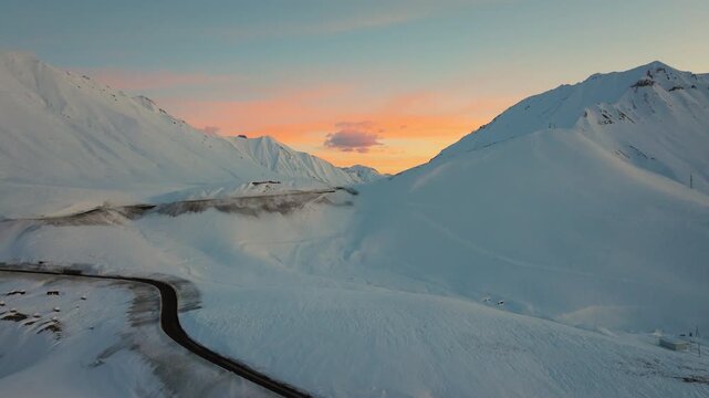 4K cinematic drone footage soaring above Gudauri during early golden-hour light, revealing vast Caucasus peaks moments before sunrise_185