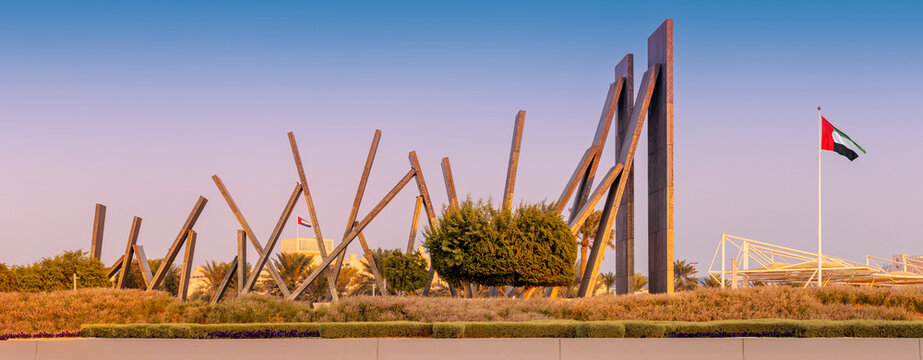5 December 2025, Abu Dhabi, UAE: Wahat Al Karama monument featuring a series of leaning aluminum panels, flag, and green landscaping
