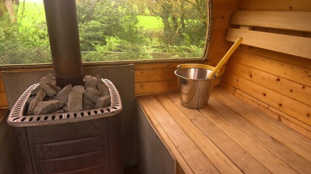 Slow pan of tranquil, wide shot of a steam-filled traditional wooden sauna interior. Luxury spa treatments, self-care routines, and stress reduction. Great for health benefits, longevity and wellness.