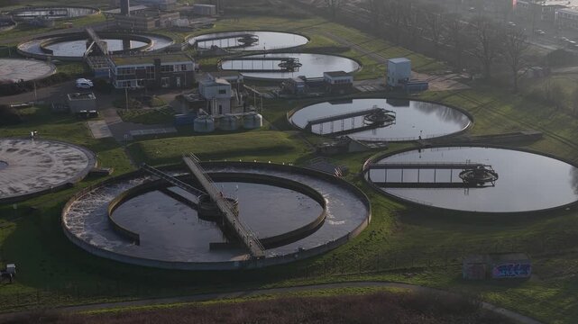 Aerial drone video of a wastewater and sewage treatment plant in Haarlem, Netherlands, showing water purification infrastructure, circular basins, environmental management, and urban sanitation system