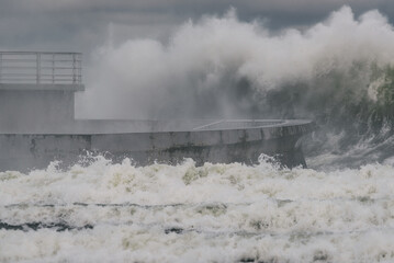 Fototapeta premium STORM AT SEA - Powerful waves of foaming sea water at the pier